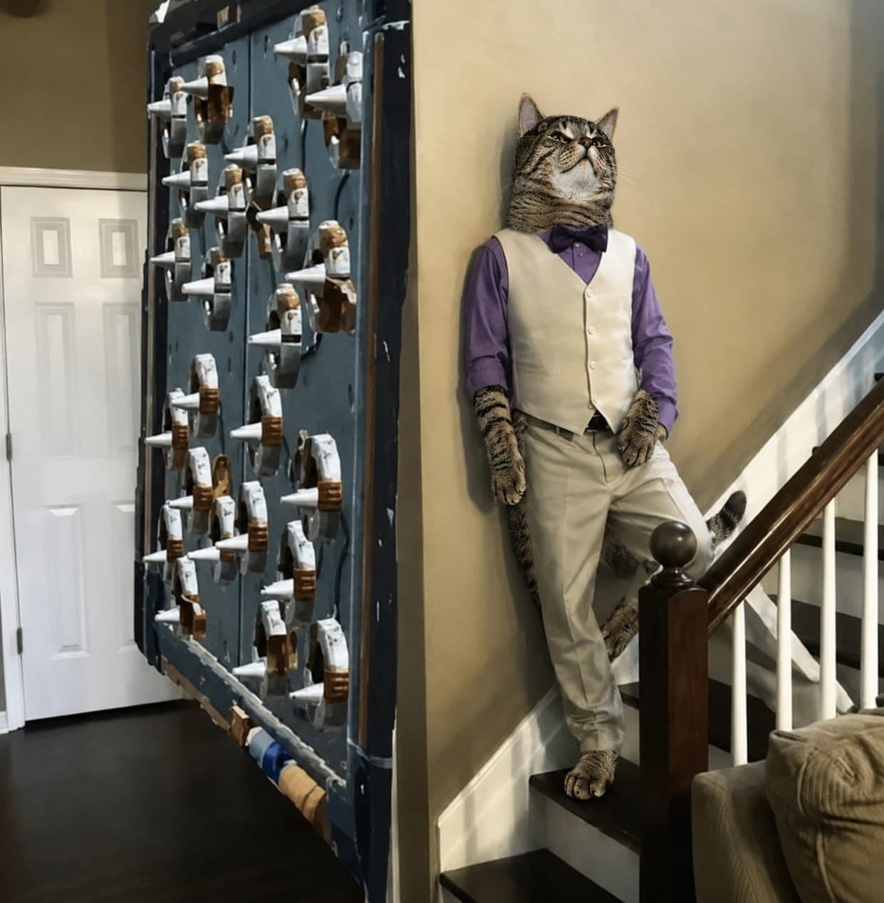 REAL in a vest and bow tie, standing on a staircase.